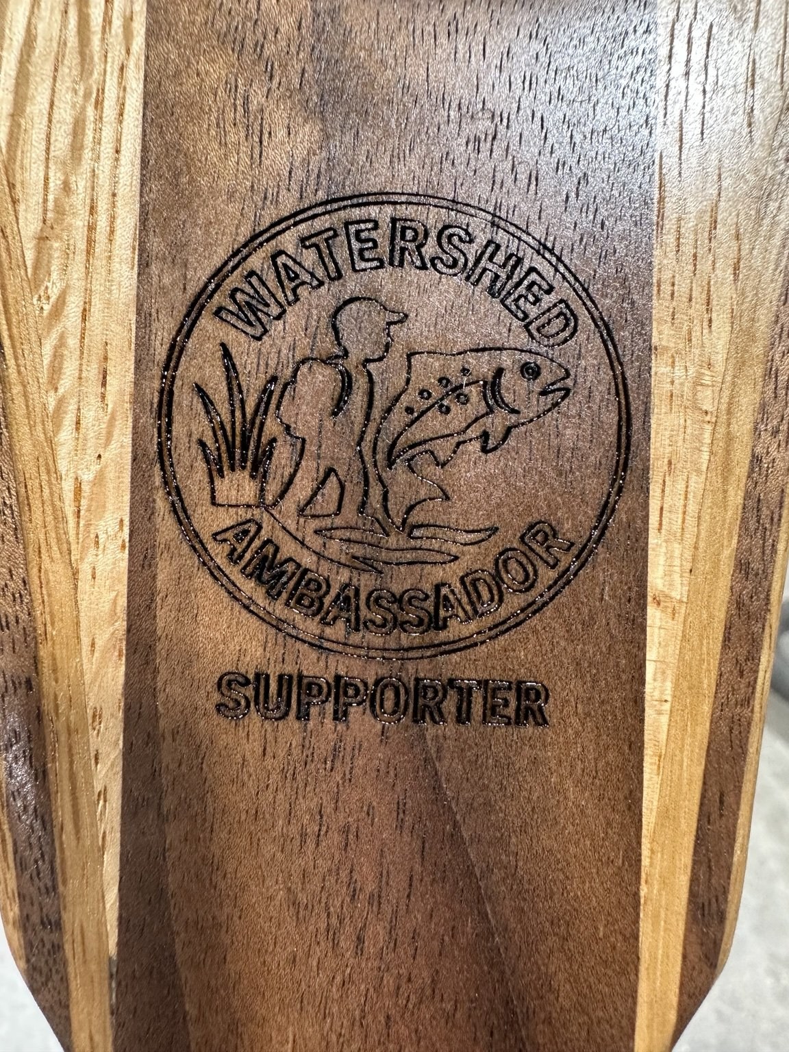 Watershed Ambassador logo engraved on a walnut handle